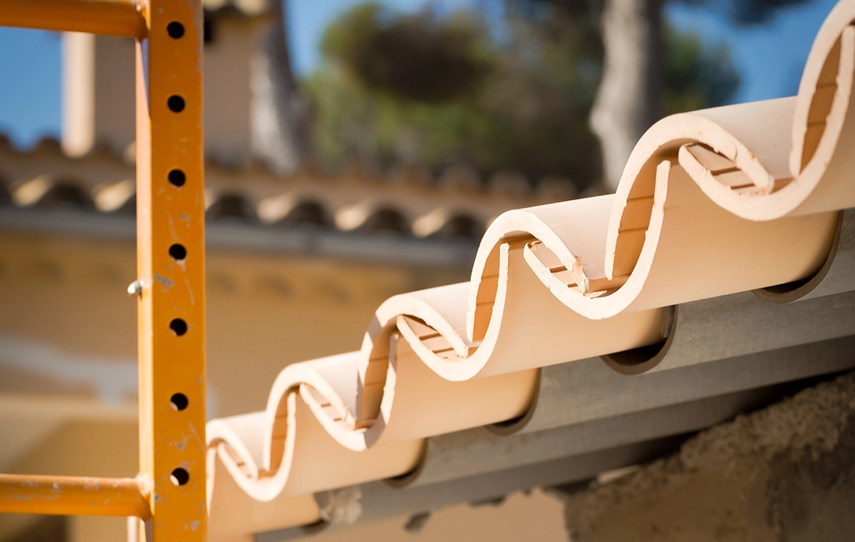 Dachdecker auf Mallorca verlegt neue Ziegel auf einer traditionellen Finca. Professionelle Dachsanierung auf den Balearen