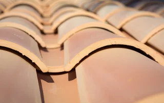 Dachdecker auf Mallorca verlegt neue Ziegel auf einer traditionellen Finca. Professionelle Dachsanierung auf den Balearen